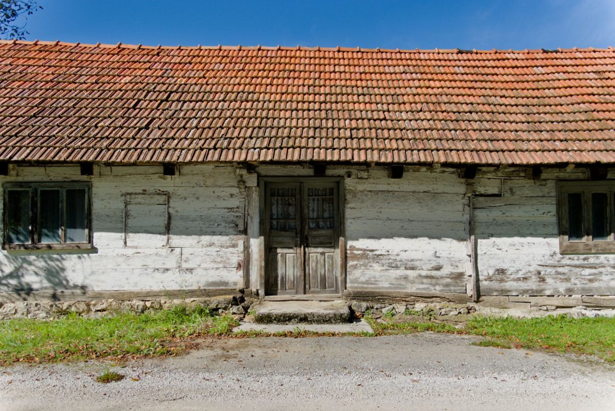 The facade of a traditional wooden house. The method of its construction is clearly visible.